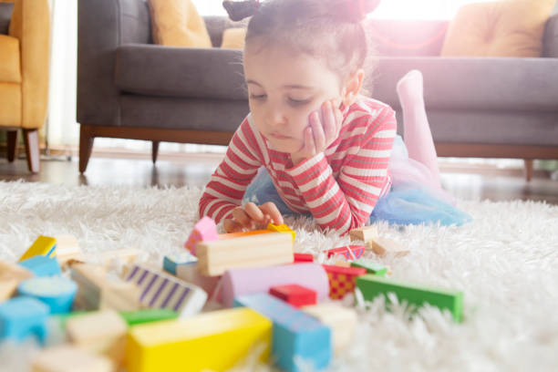 istock Little girl playing with toy blocks 1199930967