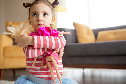 A little girl playing with dolls