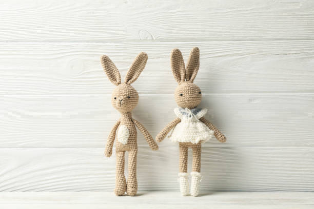 istock Toy rabbits on white wooden background, space for text 1199932475