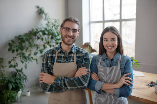istock Two smiling plant store owners wearing aprons 1199932540