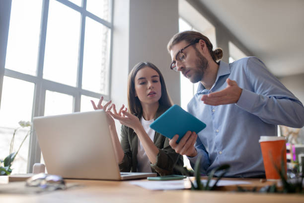 istock Work colleagues man and girl discussing new project. 1199935250