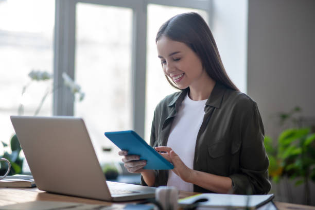 istock Young successful girl with a tablet in her hands. 1199935384