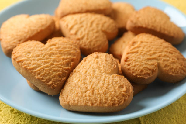 istock Plate with heart shaped cookies on yellow background, close up 1199935711