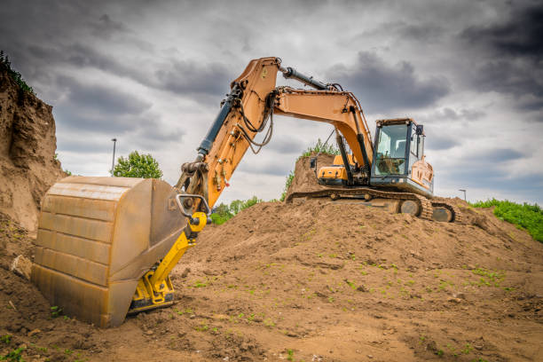 istock a yellow excavator stands on a mound of earth on a large construction site 1199939988