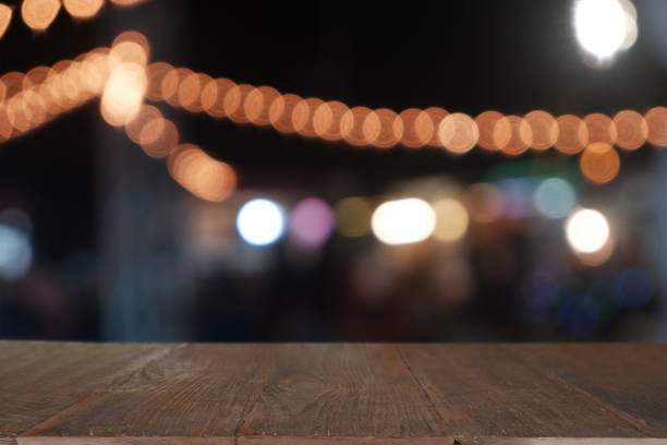 istock Empty wooden table in front of abstract blurred night light in cafe, restaurant. 1199942435