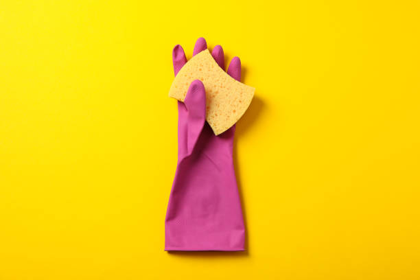 istock Cleaning glove and sponge on yellow background, space for text 1199946604