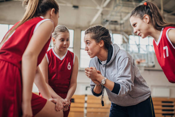istock Coach standing with basketball team 1199947664