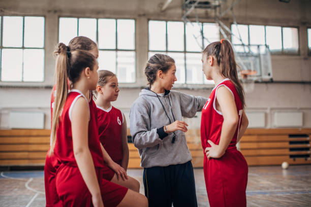 istock Coach standing with basketball team 1199948184