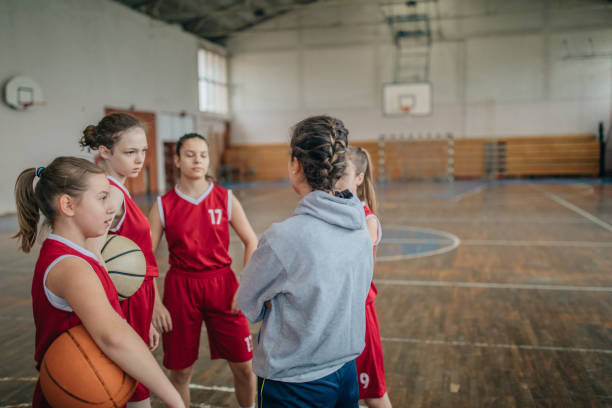 istock Coach standing with basketball team 1199948776