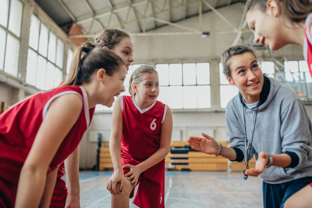 istock Coach standing with basketball team 1199948878