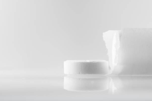 istock White large pills on a mirror surface with copy space. Medicines on a white background close up. 1199948944