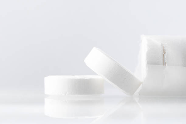 istock White large pills on a mirror surface with copy space. Medicines on a white background close up. 1199948953