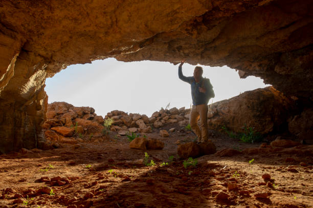 istock Mature man explores a cave at sunrise 1199949043