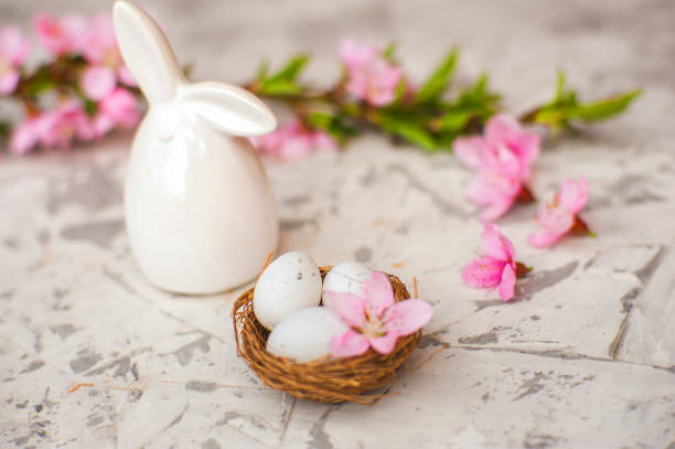 istock Spring conceptual photo with flowers. Flat lay blooming tree, easter eggs. The tree blooms pink and the eggs in the nest and copy space. 1199949659