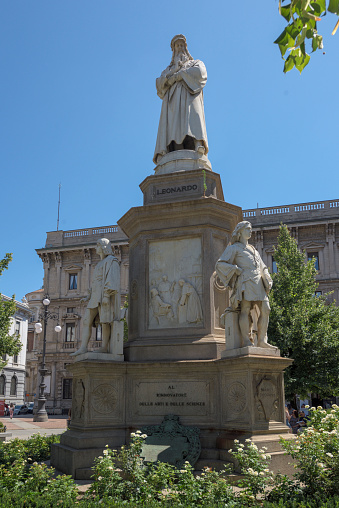 Milan, Lombardy, Italy - July 30, 2019: White Carrara marble sculpture celebrating Leonardo da Vinci by Pietro Magni in Piazza della Scala