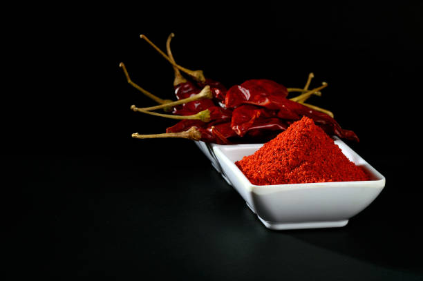 istock chilly powder with red chilly in white plate, dried chillies on black background 1199951111