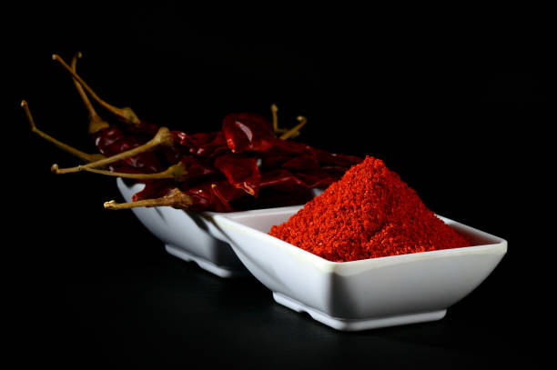 istock chilly powder with red chilly in white plate, dried chillies on black background 1199952109