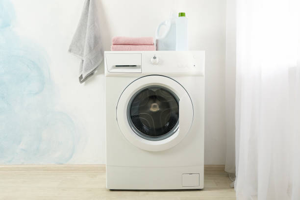 istock Modern washing machine against blue wall, space for text 1199955299