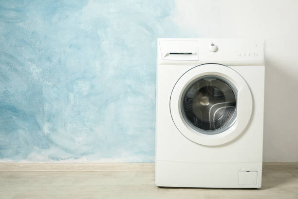 istock Modern washing machine against blue background, space for text 1199955439