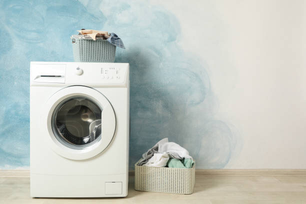 istock Laundry room with washing machine against blue wall, space for text 1199955466