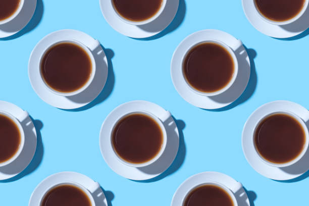 istock Pattern of cups of black coffee or tea on a blue background. 1199955603
