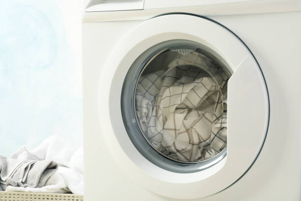 istock Laundry in a washing machine and in basket, close up 1199956337