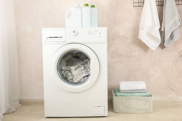 istock Laundry room with washing machine against light brown wall 1199956438