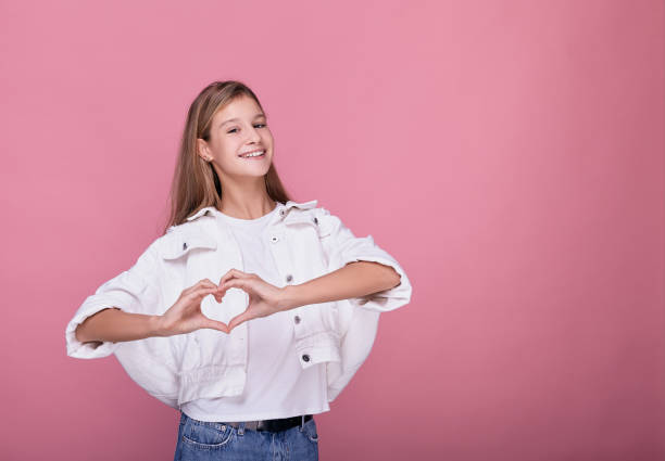 istock A young blonde smiles and shows a heart. 1199957193