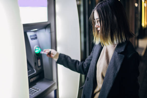 istock Withdrawing money from ATM machine 1199957975