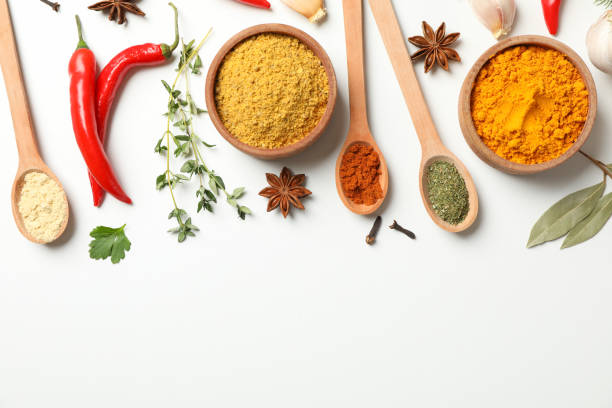 istock Spoons and bowls with different spices and ingredients on white background, space for text 1199958210