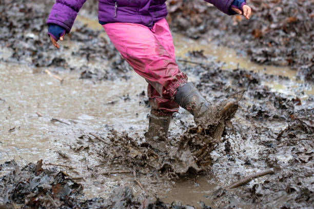 istock Young children playing in a mud puddle 1199959416