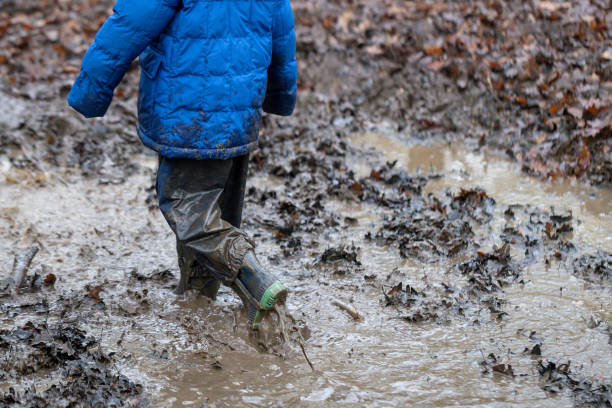 istock Young children playing in a mud puddle 1199959424