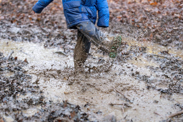 istock Young children playing in a mud puddle 1199959437