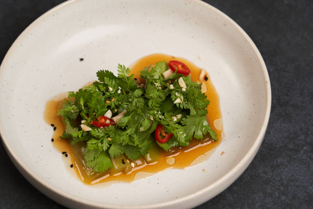 smashed cucumbers plate with red chili pepper garlic parsley and vegetable oil. - sesame cooking oil premium organic imagens e fotografias de stock