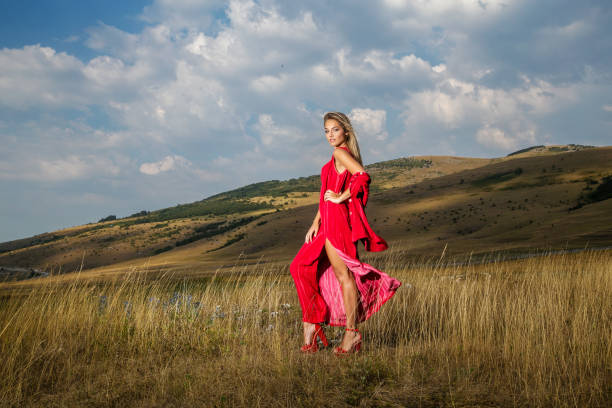 istock Beautiful young blonde enjoys walking through grass in summer 1199961740