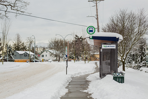 Victoria, Canada - January 15, 2020. A BC Transit bus stop in the snow. When it snows in Victoria, limited bus services are available.