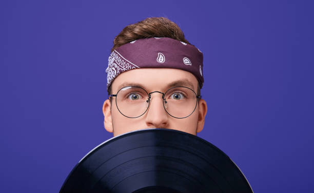 istock Surprised guy with glasses and a bandana with a record player. 1199964090