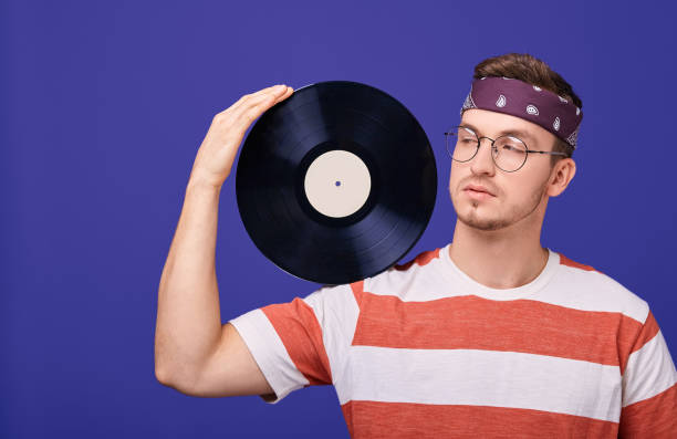 istock A handsome guy with glasses and a bandana holds a record on his shoulder. 1199964106