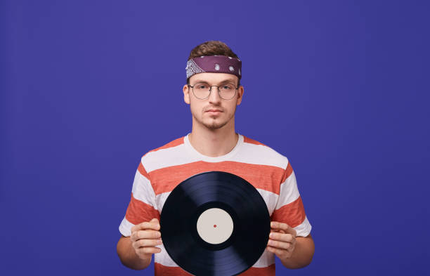 istock A handsome guy holds a music record in his hands. 1199964143