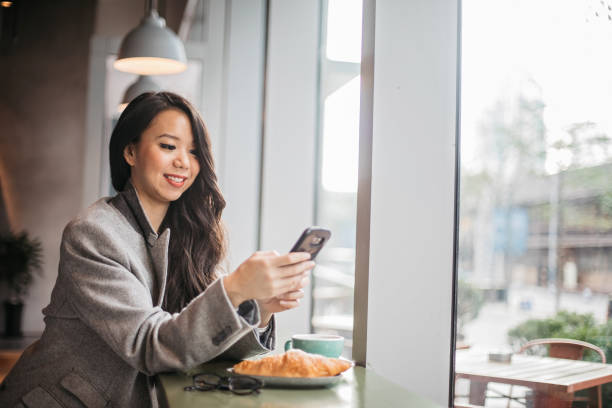 istock Pretty woman is using phone at breakfast 1199966747