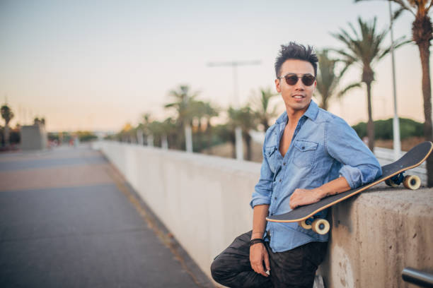 istock Guy with skateboard standing on the street 1199967787