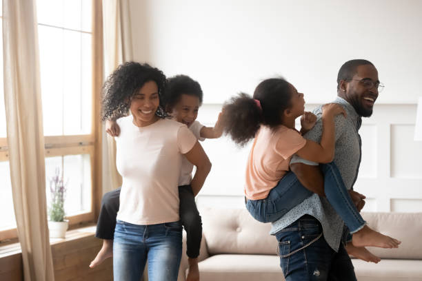 istock Happy black couple playing with kids on backs. 1199968728