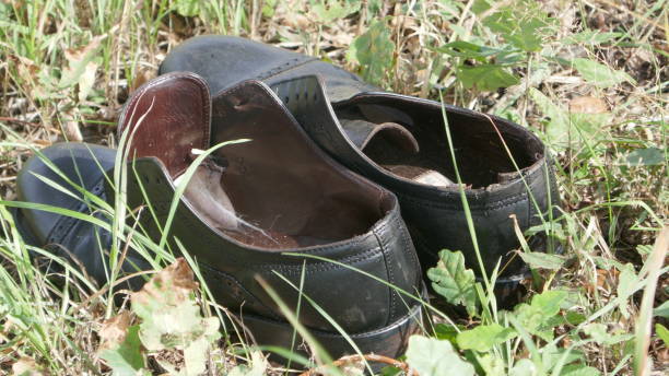 istock Abandoned black men's shoes on the roadside. 1199968918