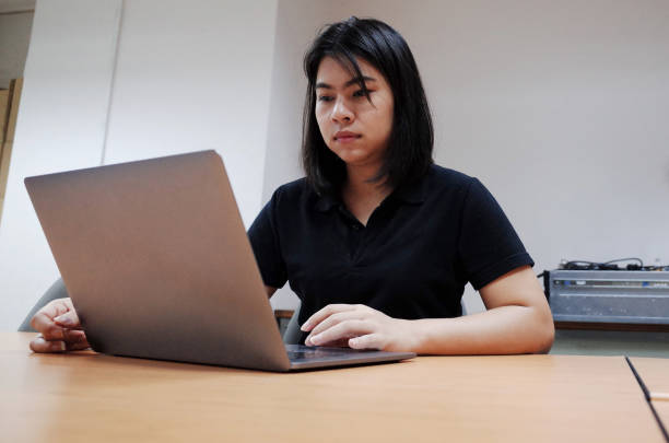 istock women using laptop search information on desk. 1199970494