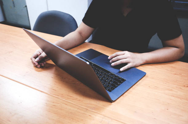 istock women using laptop search information on desk. 1199970503
