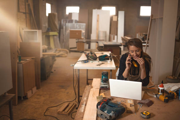 Young woman worker in the carpenter workroom.