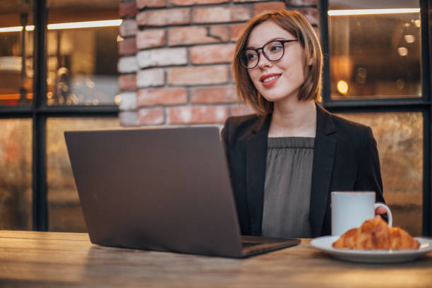istock Elegant young woman is using laptop 1199971437