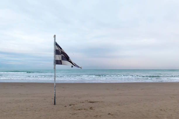 istock Waving old flag on the empty beach. 1199971770