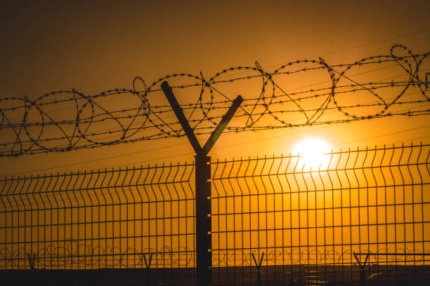istock Barbed wire steel wall against the immigations 1199974157