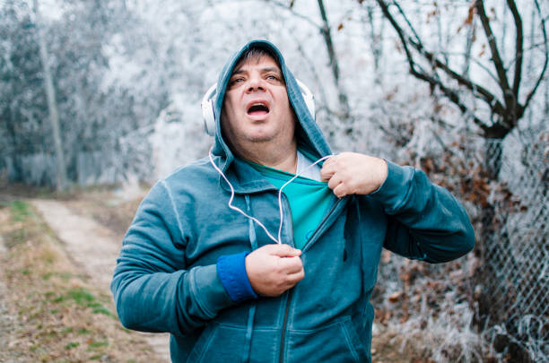 Sweating is the best way for burning calories Mature Overweight tired Man on jogging outdoors taking off his sweat shirt chubby arab stock pictures, royalty-free photos & images